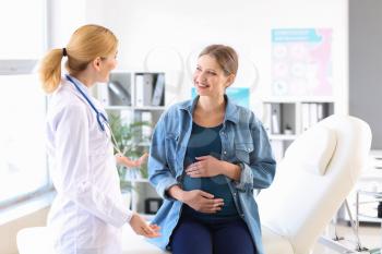 Young pregnant woman visiting her gynecologist in clinic 