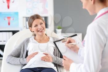Young pregnant woman visiting her gynecologist in clinic�