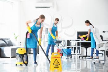 Team of janitors cleaning office�