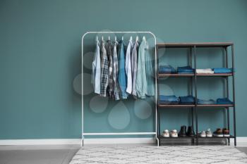 Rack with stylish clothes and shoes in dressing room�