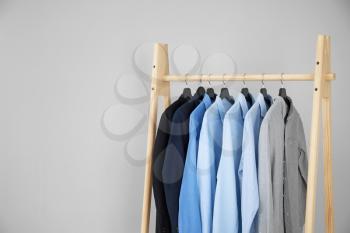 Rack with stylish male clothes on light background�