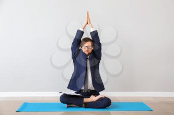 Businessman practicing yoga indoors�