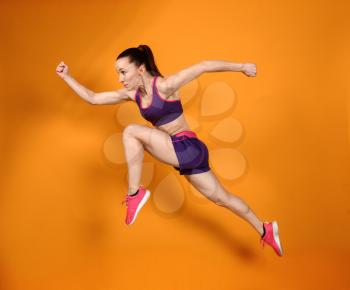 Sporty running woman on color background�