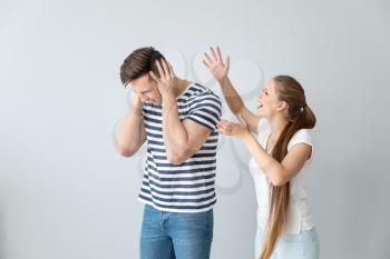 Young quarrelling couple on light background�
