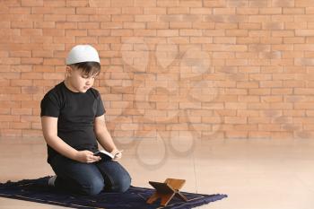 Little Muslim boy praying indoors�