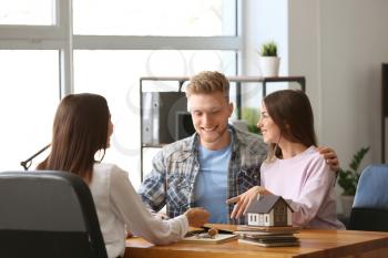 Young couple in office of real estate agent�