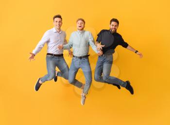 Jumping young men on color background�