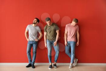 Fashionable young men near color wall�