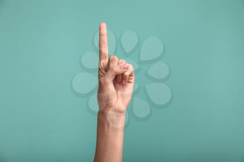 Gesturing female hand on color background�