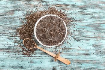 Bowl and spoon with chia seeds on wooden table�