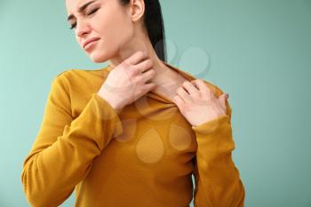 Young woman with skin allergy on color background�