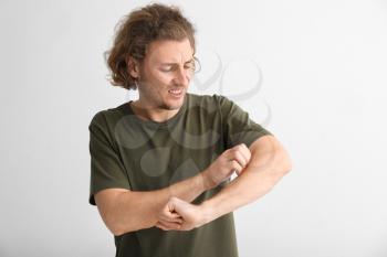 Young man with skin allergy on light background�
