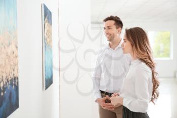 Couple at exhibition in modern art gallery�
