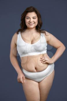 Beautiful plus size woman on grey background. Concept of body positive�