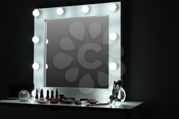 Table with cosmetics and mirror in modern makeup room�
