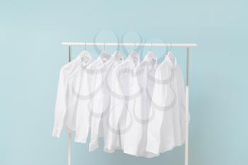 Rack with clothes after dry-cleaning on light background�