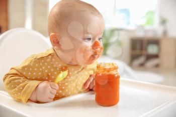 Cute little baby eating tasty food at home�