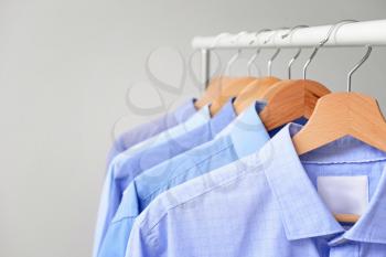 Rack with clothes after dry-cleaning on light background, closeup�