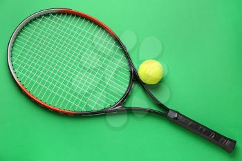 Tennis racket and ball on color background�