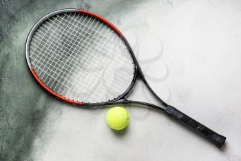Tennis racket and ball on color background�