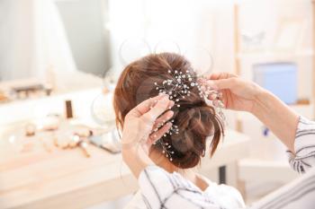 Professional hairdresser working with young bride at home�