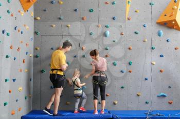 Little girl with parents in climbing gym�