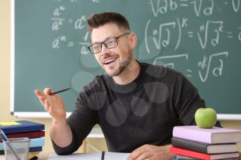 Handsome math teacher conducting lesson in classroom�