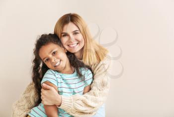 Happy woman with little adopted African-American girl on white background�