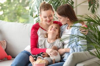 Happy lesbian couple with little daughter at home�