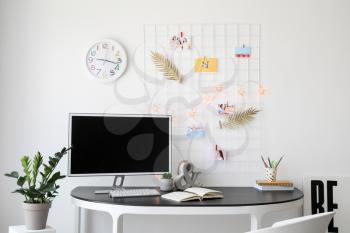 Workplace with mood board and computer in modern room�