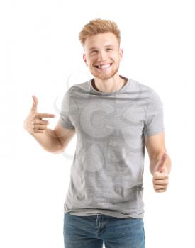 Man pointing at his t-shirt and showing thumb-up against white background�
