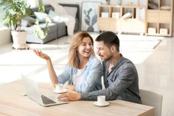 Happy couple in love using laptop at home�