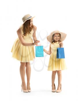 Portrait of beautiful woman and her little daughter with shopping bags on white background�