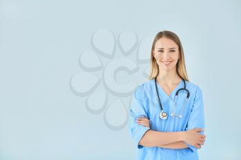 Female nurse with stethoscope on color background�