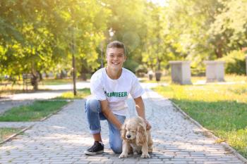 Teenage volunteer with cute dog outdoors�