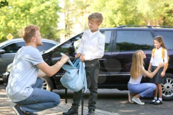 Parents getting their children ready for school outdoors�