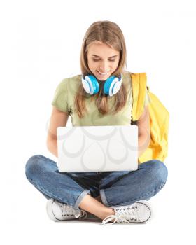 Portrait of young student with laptop and headphones on white background�
