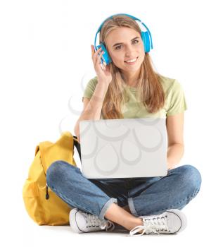 Portrait of young student with laptop and headphones on white background�