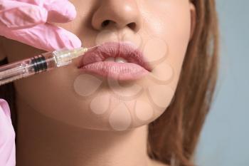 Young woman receiving injection of filler in lips, closeup�