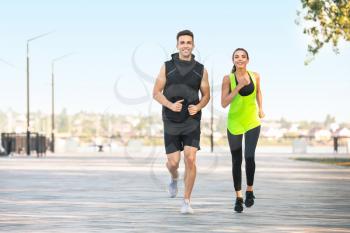 Sporty young couple running outdoors�