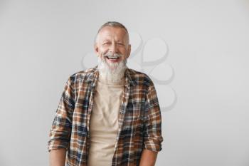Happy mature man on grey background�