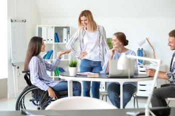 Handicapped young woman with colleagues working in office�