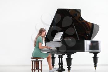 Young woman playing grand piano at the concert�