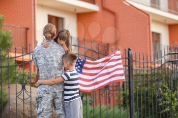 Sad little children saying goodbye to their military father outdoors�