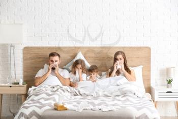 Family ill with flu in bed at home�