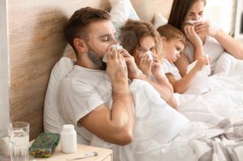 Family ill with flu in bed at home�