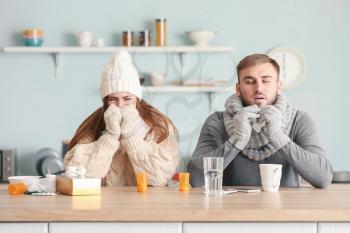 Sick couple sitting at kitchen table�