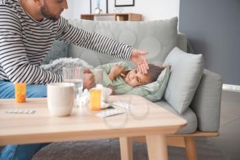 Father taking care of his daughter ill with flu at home�