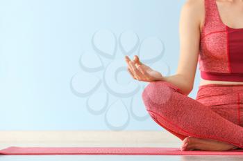 Young woman meditating in gym�