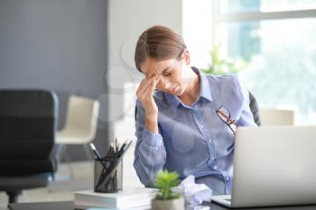 Young woman suffering from headache in office�